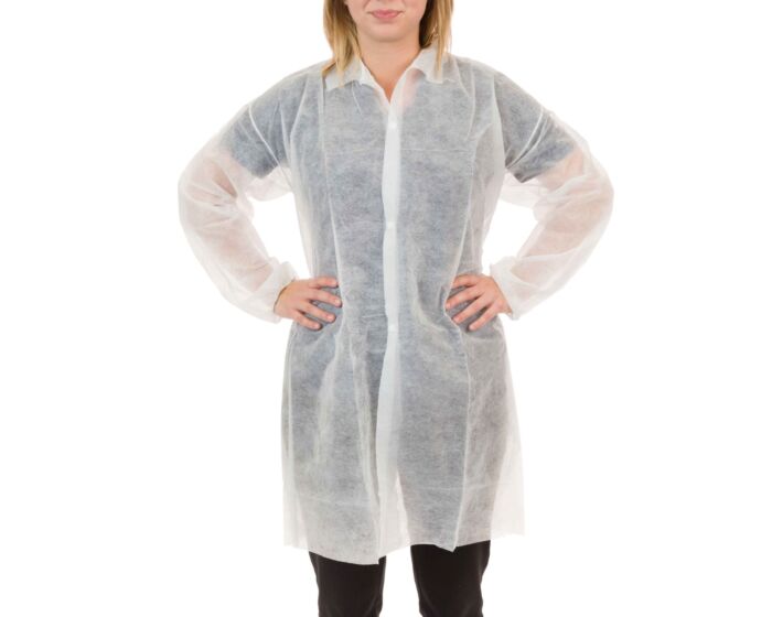 Person wearing a white disposable lab coat on a white background