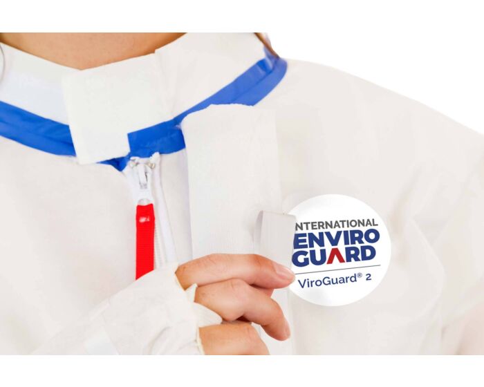 Person wearing a white shirt with blue and red accents, holding an International EnviroGuard product.